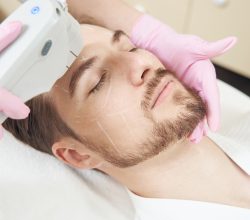 Man resting with shut eyes while getting SMAS lifting for skin on his face